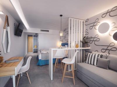 Modern eingerichteter Wohnbereich mit grauem Sofa, weißem Tisch, Holzstühlen und dekorativem Wandschmuck.