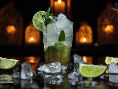 Ein erfrischender Cocktail mit Limette und Minze, umgeben von Eiswürfeln und Limettenscheiben.