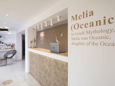 Heller Hotelempfang mit modernem Tresen und dekoriertem Schriftzug an der Wand.