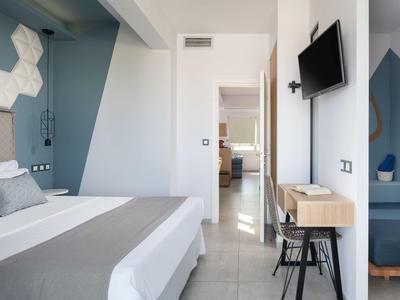 Helles modernes Schlafzimmer mit Doppelbett, blauen Wandelementen, Fernsehgerät und Holzmöbeln.