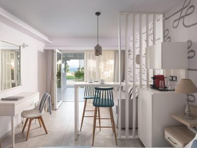 Moderner Hotelraum mit Tresen, Stühlen und Blick auf einen Pool im Freien.