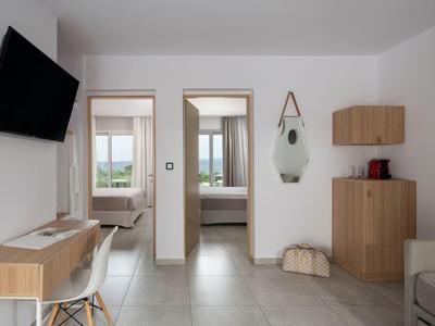 Moderner, heller Wohnraum mit Blick auf ein Schlafzimmer und minimalistischer Einrichtung.