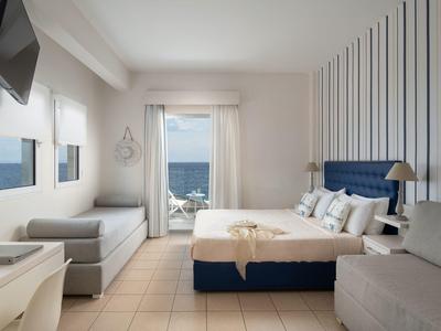 Modernes Hotelzimmer mit Doppelbett, Balkon und Blick aufs Meer.
