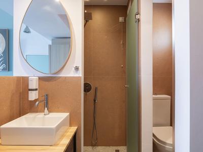 Modernes Badezimmer mit rechteckigem Waschbecken, ovalem Spiegel und separater Duschkabine.