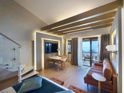 Modern eingerichtetes Hotelzimmer mit Balkon und Blick auf das Meer.