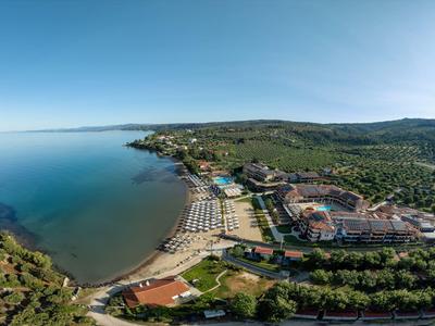 Strandresort mit Hotelanlagen, Liegestühlen am Sandstrand und ruhigem, blauem Meer.