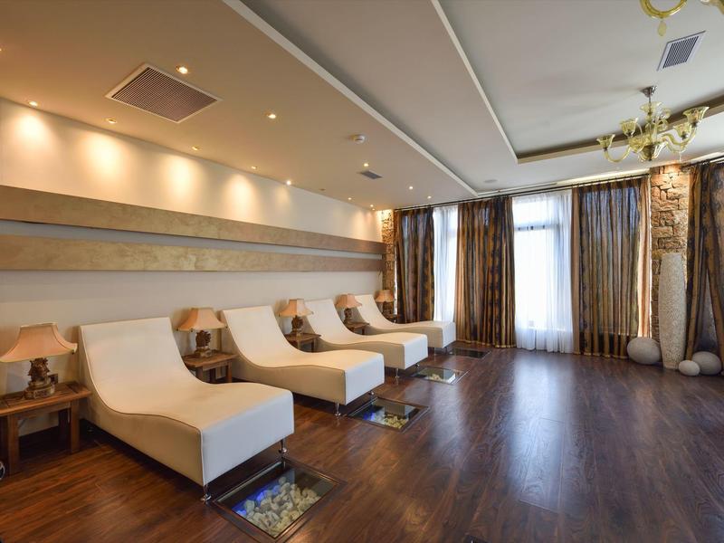 Moderner Wellnessraum mit bequemen Liegen, Holzfußboden und gedämpftem Licht.