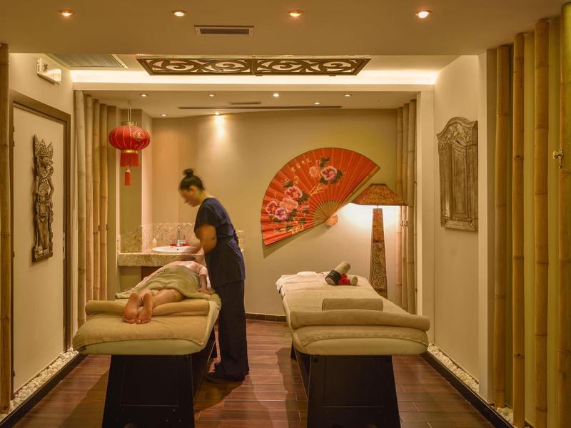 Ein ruhiger Wellnessbereich mit zwei Massageliegen, dekoriert mit asiatischen Elementen.