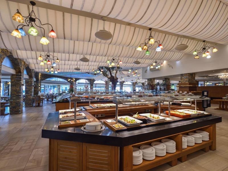 Großer Buffetbereich in einem hellen Restaurant mit vielfältigen Speisen und moderner Beleuchtung.