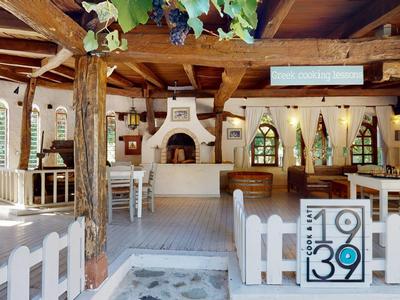 Aerial view of a resort with pool, tennis court, and sparkling sea view.