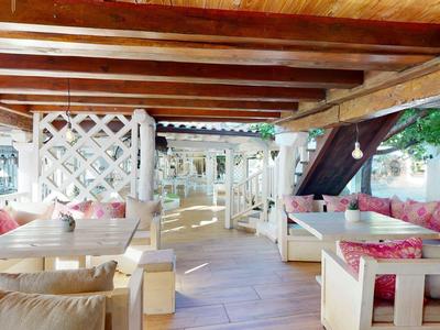 Houten interieur van een open lounge met banken en kussens in een gezellige hotelruimte