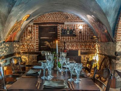 Accogliente sala da pranzo rustica con pareti in mattoni e tavolo elegantemente apparecchiato.