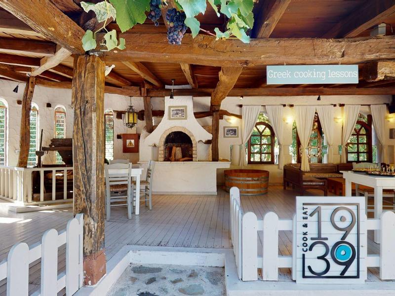 Aerial view of a resort with pool, tennis court, and sparkling sea view.