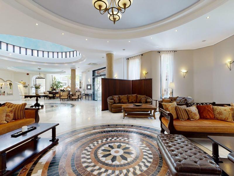 Spacious, elegant hotel lobby with marble flooring, cozy sofas, and stylish lighting.