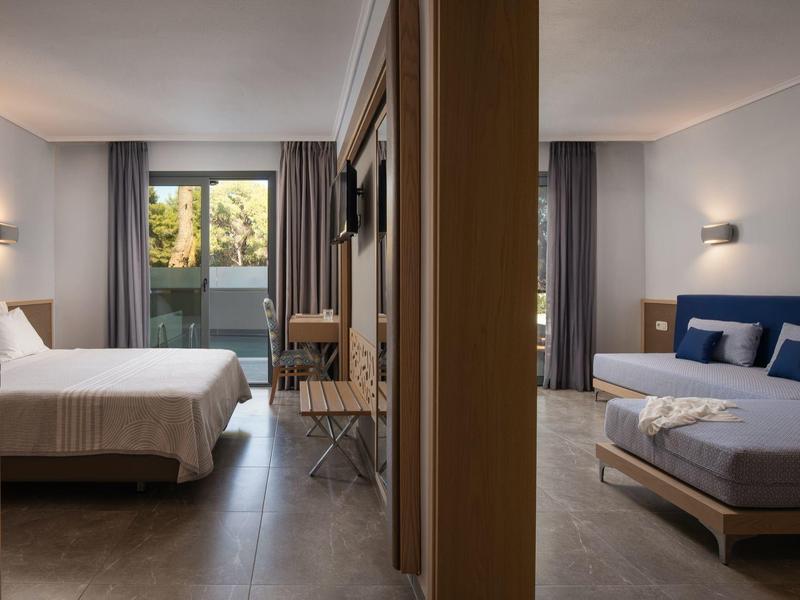 Deux chambres d'hôtel modernes avec lits, bureaux et grandes fenêtres séparées par un mur.