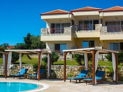 Moderní rekreační dům s terasou a bazénem pod modrou oblohou.