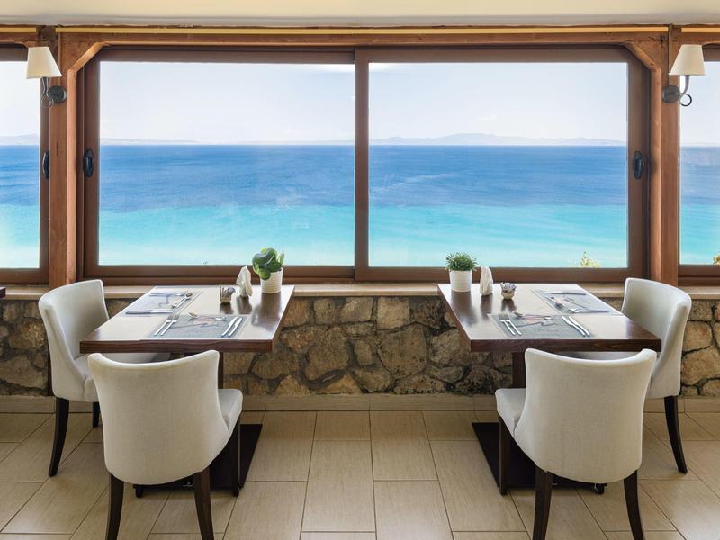 Malá restaurace s výhledem na modré moře přes velká okna