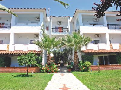 Ingresso di un edificio di hotel su tre piani con pareti bianche e balconi