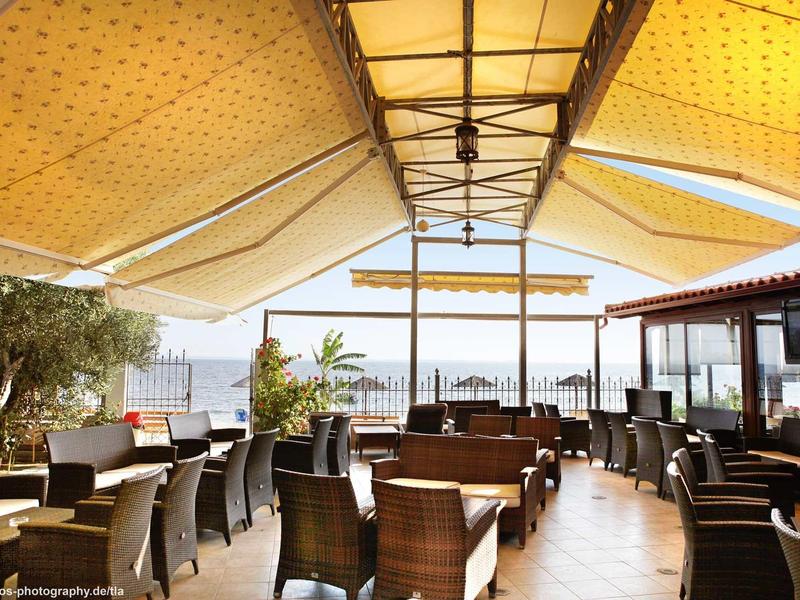 Terrazza coperta di ristorante con vista mare e sedie imbottite