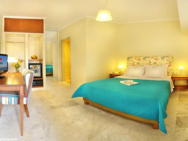 Camera d'albergo luminosa con letto matrimoniale, scrivania, TV e comfort moderni.