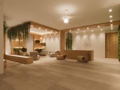 Moderní hotelová hala s dřevěnou výzdobou, rostlinami a pohodlnými sedačkami.