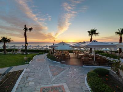 Sonnenterasse mit Sitzbereich und Blick auf das Meer bei Sonnenuntergang.