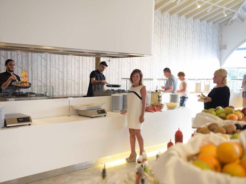 Hotelová hala s jídelní částí a hosty v uvolněné atmosféře