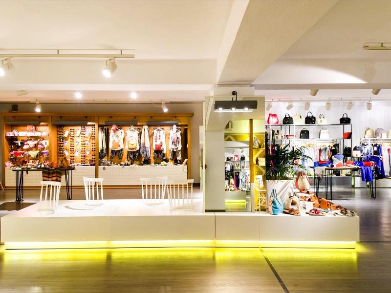 Moderní prodejní prostor s jasnými policemi a osvětlenou sedací plochou.