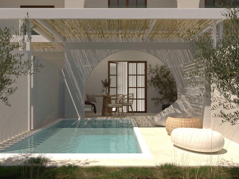 Moderní venkovní bazén s odpočinkovými plochami vedle světlého, minimalistického domu.