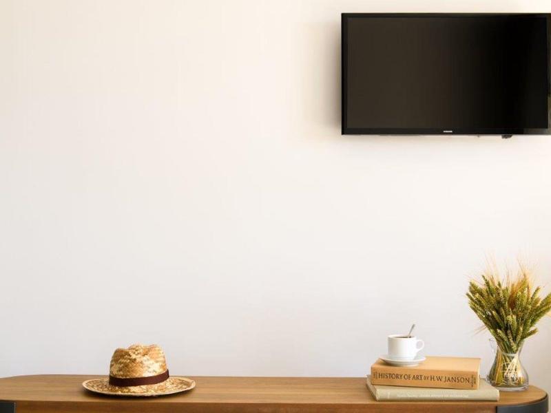 Moderní pokoj s dřevěnou konzolí, televizí na zdi a dekorativními prvky