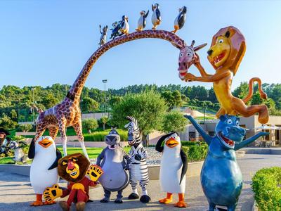 Postavy z filmu Madagaskar v barevných velkých sochách na slunečném venkovním parku.