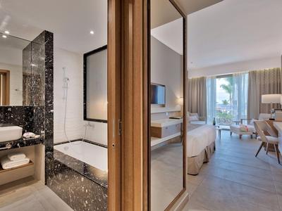 Moderní hotelový pokoj s koupelnou s mramorem a ložnicí s balkonem.