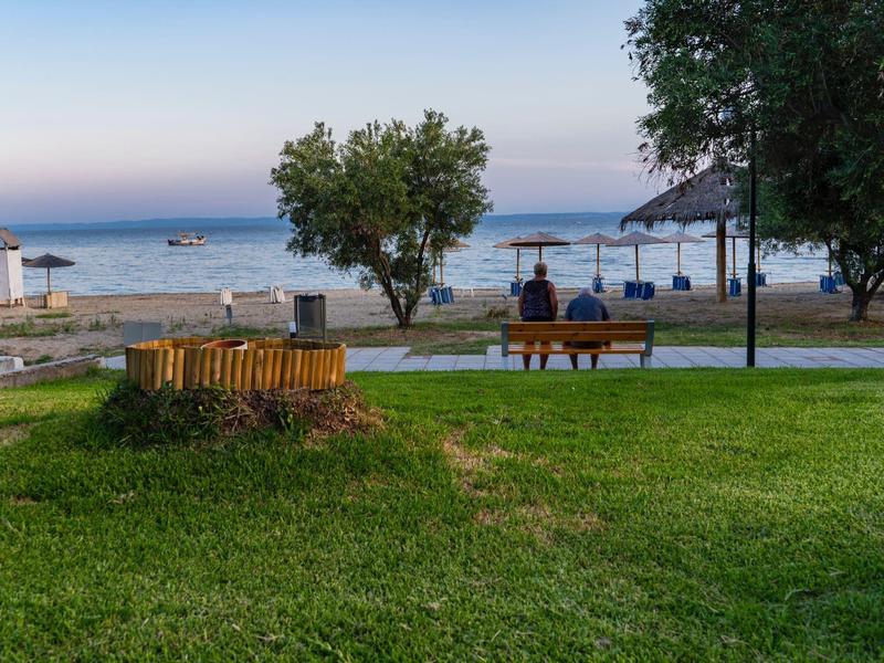 Zielony park z ławkami z widokiem na morze o zmierzchu