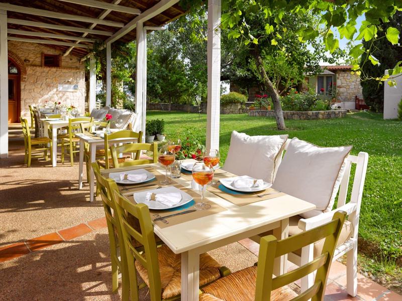 Cozy terrace with set tables next to a green garden area.