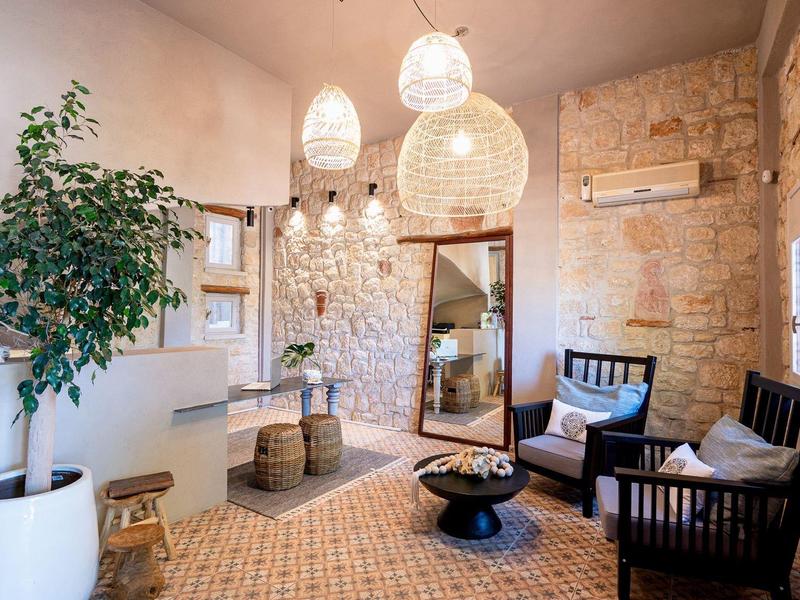 Cozy living area with stone wall, plants, vintage lamps, and seating furniture.