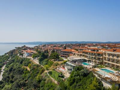 Kompleks hotelowy z basenami na klifie z widokiem na morze i okoliczne wzgórza.