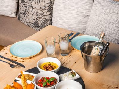 Dania na drewnianym stole z tarasem i widokiem na morze.