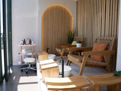 Nowoczesna poczekalnia z drewnianymi krzesłami i ozdobnym oświetlonym drewnem na ścianie