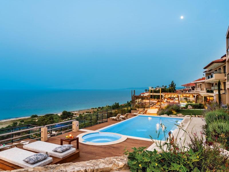 Taras hotelowy z basenem i widokiem na morze o zmierzchu