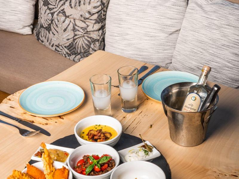 Dania na drewnianym stole z tarasem i widokiem na morze.