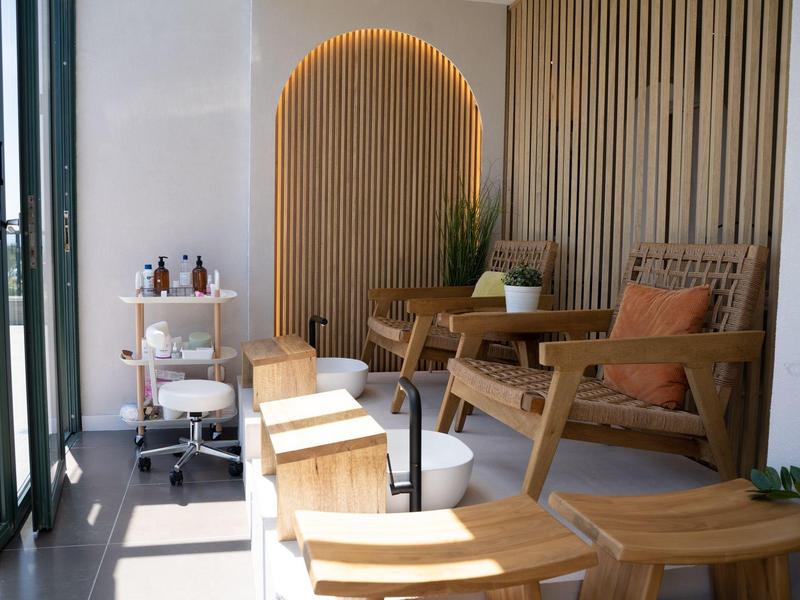 Nowoczesna poczekalnia z drewnianymi krzesłami i ozdobnym oświetlonym drewnem na ścianie