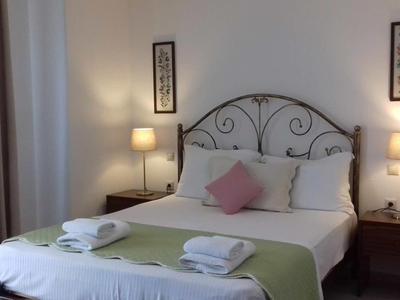 Accogliente camera d'hotel con letto matrimoniale, comodini e illuminazione soffusa.