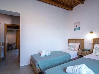 Modern hotelkamer met twee eenpersoonsbedden en houten balkenplafond.