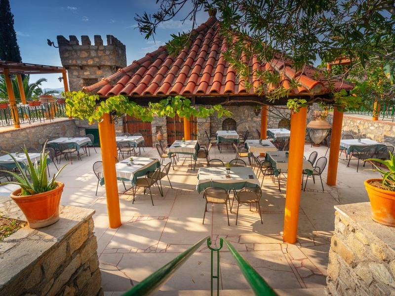 Gezellig zitgedeelte onder een betegelde pergola aan zee.