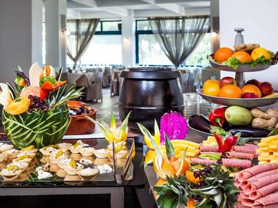 Buffet con frutas frescas, verduras y varios fiambres en un restaurante.