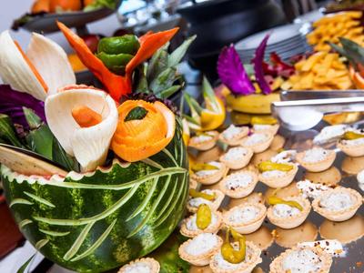 Aperitivos dulces en un buffet decorado con frutas tropicales festivas.