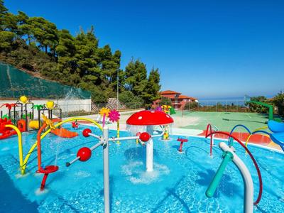 Área de juegos acuáticos con estructuras coloridas y toboganes bajo cielo azul despejado