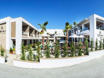 Nowoczesny hotel z białą fasadą, przestrzenią na zewnątrz i palmami pod czystym niebem.