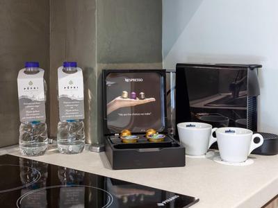 Station de café moderne avec deux bouteilles d'eau, une machine à café et deux tasses sur un comptoir de cuisine