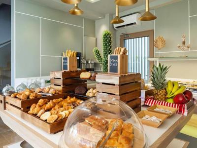 Buffet petit-déjeuner avec divers pains, fruits et un cadre moderne aux couleurs chaudes.